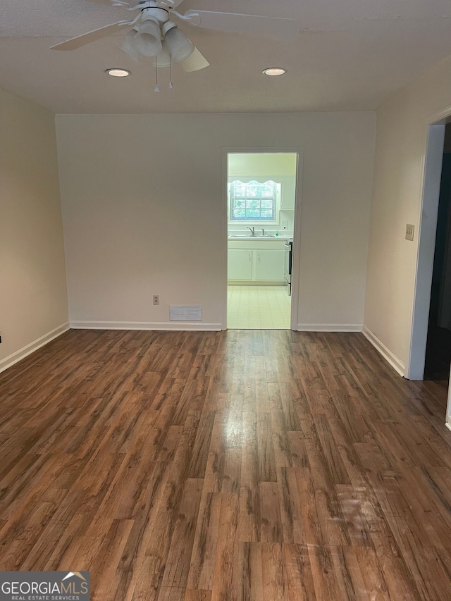 spare room with ceiling fan, dark hardwood / wood-style floors, and sink