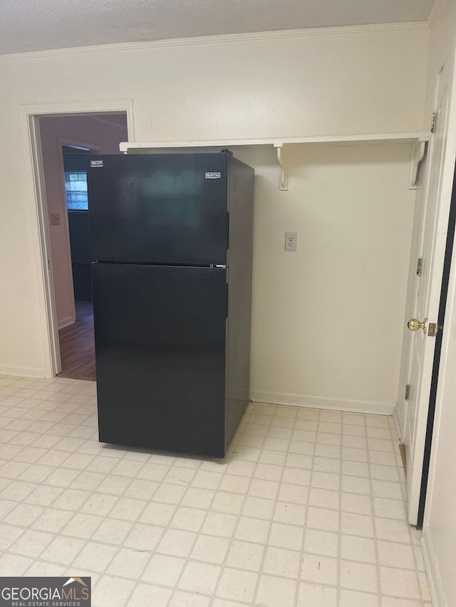 interior space with black refrigerator and crown molding