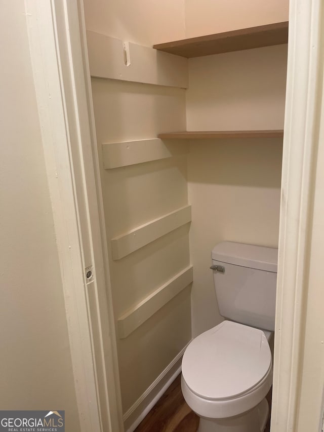 bathroom with toilet and wood-type flooring