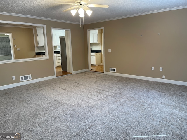 empty room with ceiling fan, carpet, and a textured ceiling