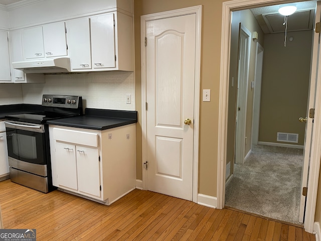 kitchen featuring backsplash, electric stove, white cabinetry, and light hardwood / wood-style flooring