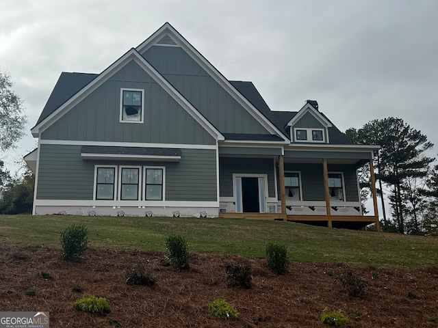 view of front of house featuring covered porch and a front yard