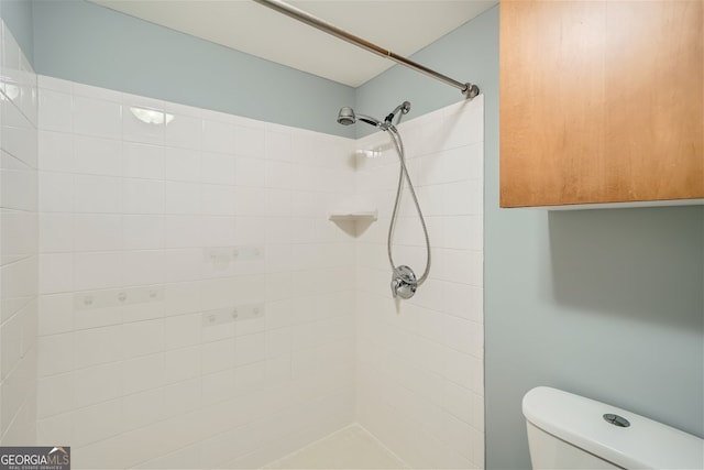 bathroom featuring toilet and a tile shower