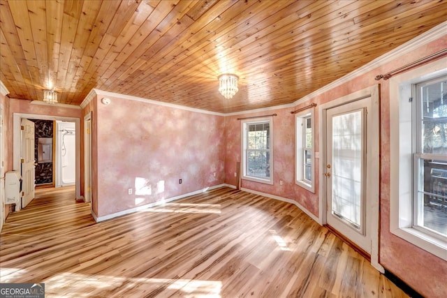 spare room featuring a chandelier, crown molding, light hardwood / wood-style flooring, and wood ceiling