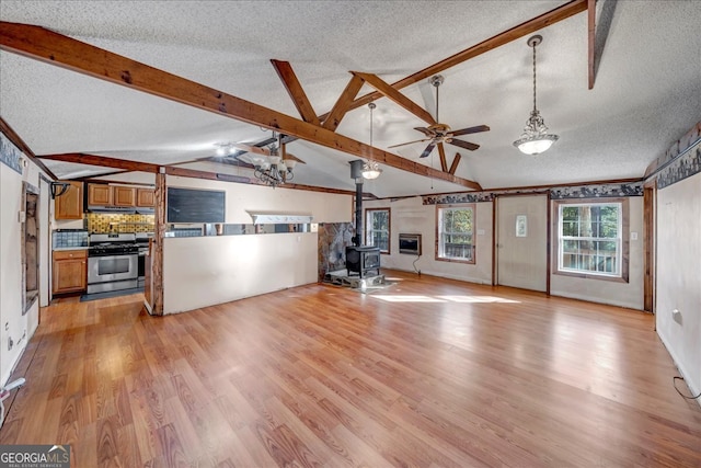 unfurnished living room featuring a textured ceiling, light hardwood / wood-style floors, and a wood stove