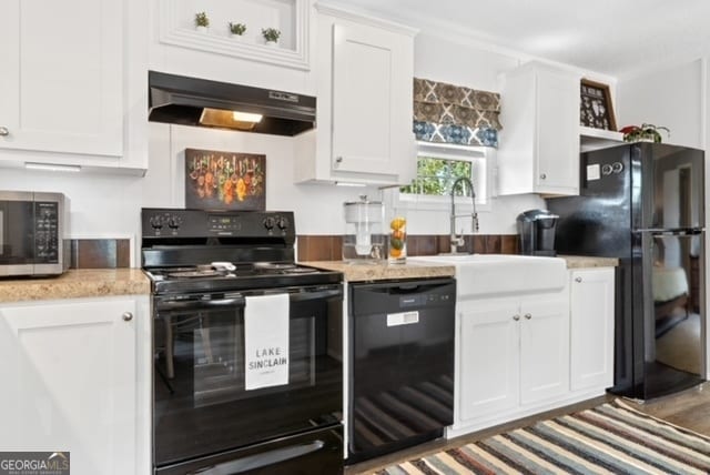 kitchen featuring white cabinetry, dark wood-type flooring, black appliances, range hood, and sink