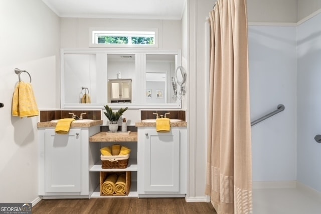 bathroom featuring ornamental molding, wood-type flooring, and sink