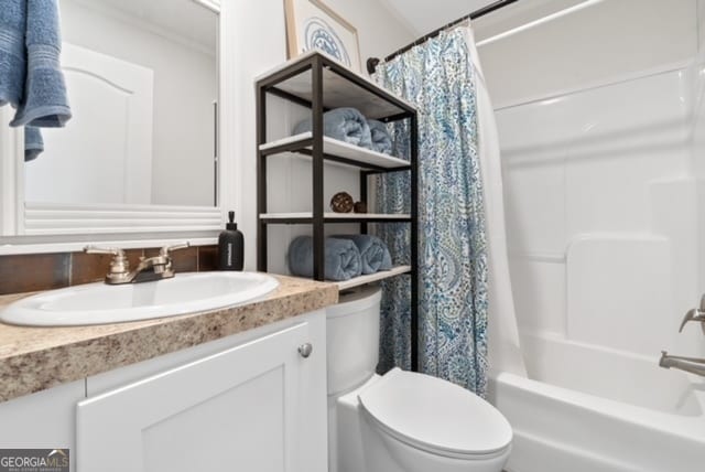 full bathroom featuring shower / tub combo with curtain, crown molding, vanity, and toilet