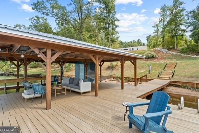 view of dock featuring an outdoor hangout area, a deck, and a gazebo