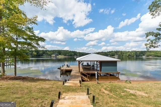 dock area with a water view and a yard