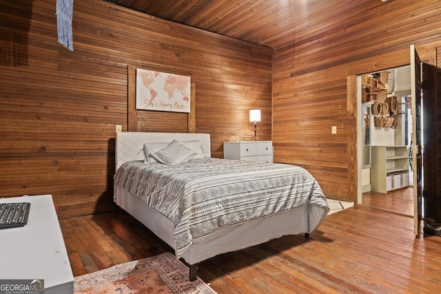 bedroom with wood-type flooring and wood walls