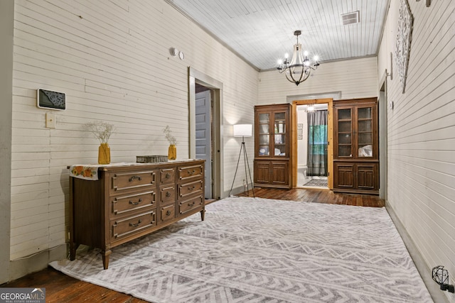 entryway with wooden walls, dark hardwood / wood-style floors, and a chandelier