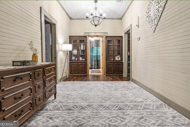 corridor with wooden walls and a chandelier