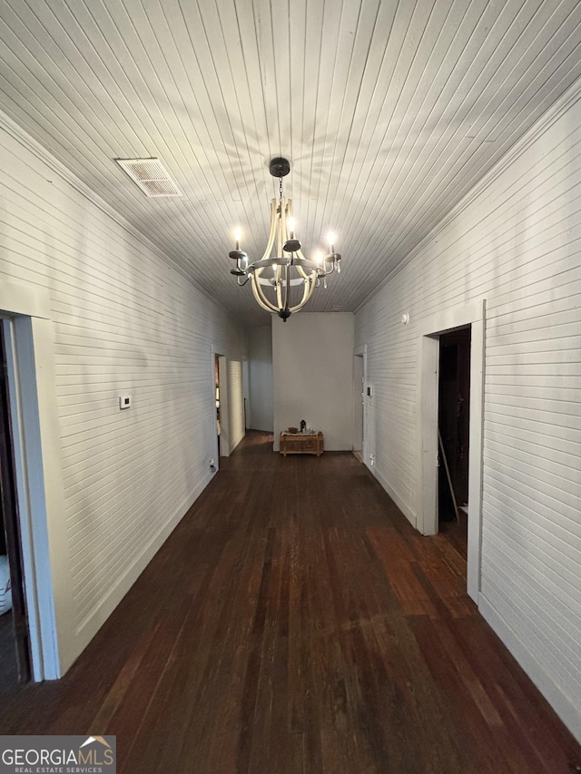 hallway featuring dark hardwood / wood-style floors and a chandelier