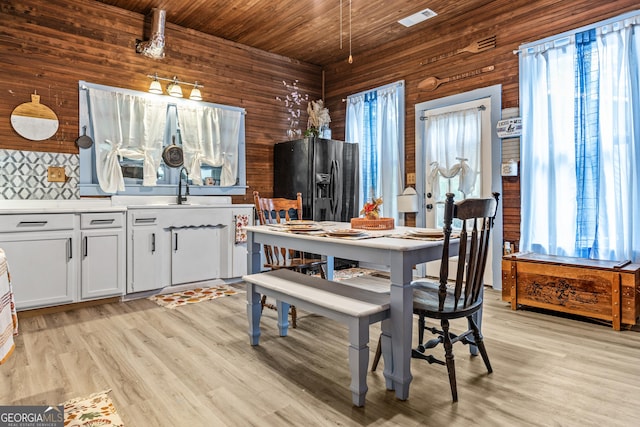 dining room with sink, a wealth of natural light, wooden ceiling, and light hardwood / wood-style floors