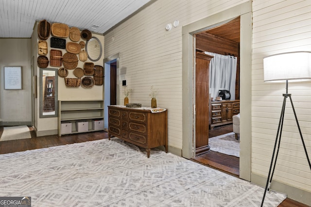 hallway featuring wood-type flooring and wood walls