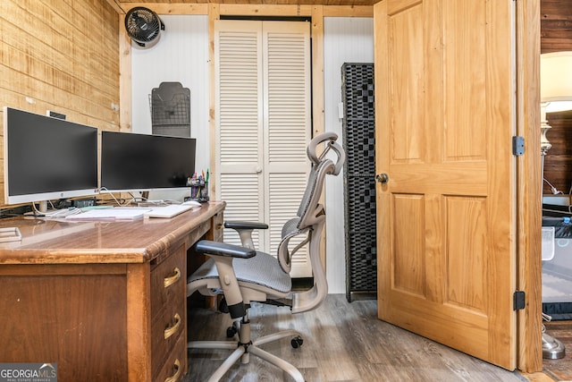 office featuring wood-type flooring and wood walls