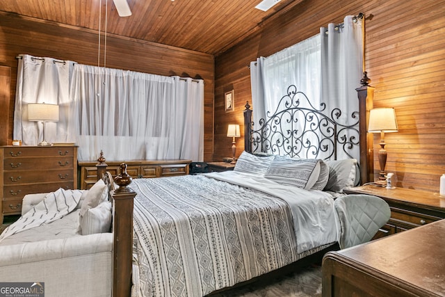 bedroom featuring ceiling fan, wooden ceiling, and wooden walls