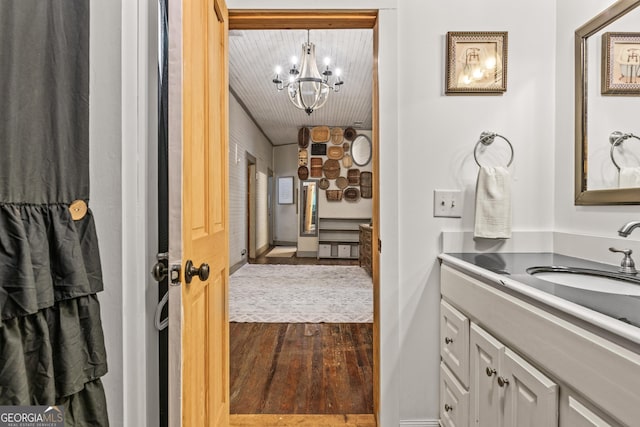 bathroom with wood-type flooring, a chandelier, and vanity