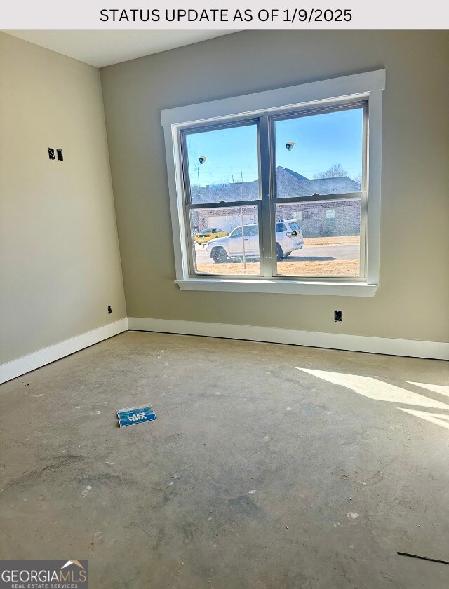 unfurnished room with concrete flooring