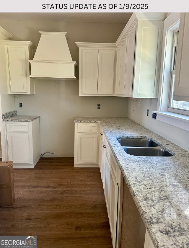 kitchen featuring custom exhaust hood, white cabinets, sink, light stone counters, and dark hardwood / wood-style flooring