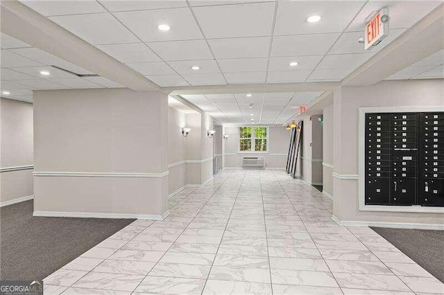 hallway featuring recessed lighting, marble finish floor, baseboards, and a drop ceiling