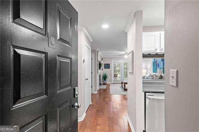 corridor with recessed lighting, baseboards, wood finished floors, and crown molding