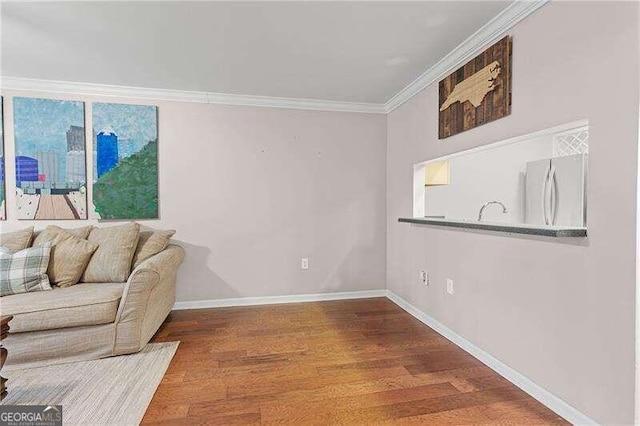 interior space featuring baseboards, wood finished floors, and crown molding