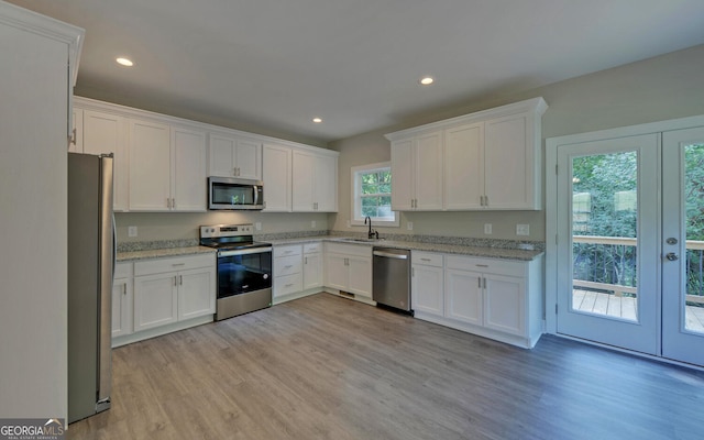 kitchen featuring french doors, white cabinets, a sink, and stainless steel appliances