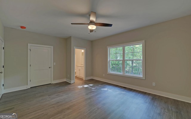 unfurnished bedroom featuring ensuite bath, ceiling fan, and dark hardwood / wood-style floors