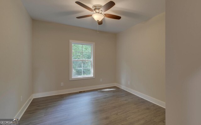 spare room featuring dark wood-type flooring and ceiling fan