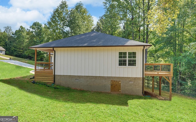 view of side of property featuring a yard and a wooden deck