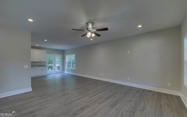 unfurnished living room with hardwood / wood-style floors, ceiling fan, and french doors