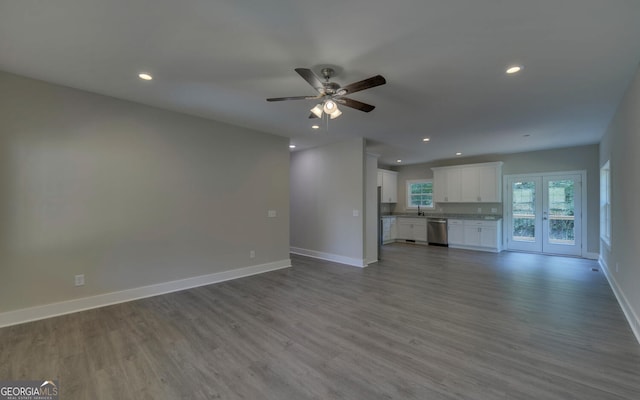 unfurnished living room featuring light hardwood / wood-style flooring, sink, and ceiling fan