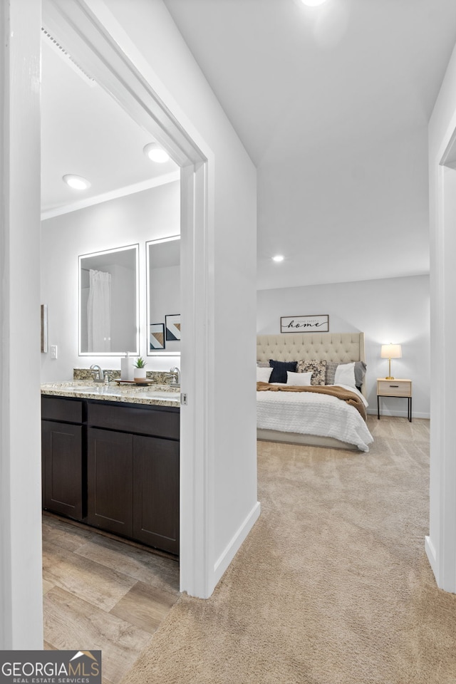 bedroom featuring sink and light carpet