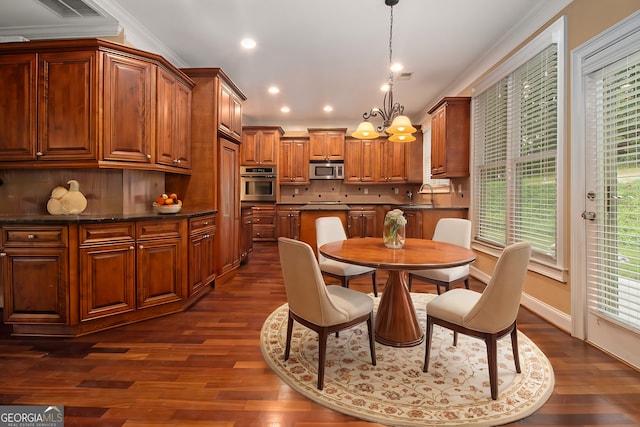 kitchen featuring dark stone countertops, appliances with stainless steel finishes, decorative backsplash, and dark hardwood / wood-style floors