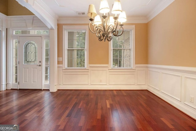 spare room featuring ornamental molding, an inviting chandelier, and dark hardwood / wood-style floors