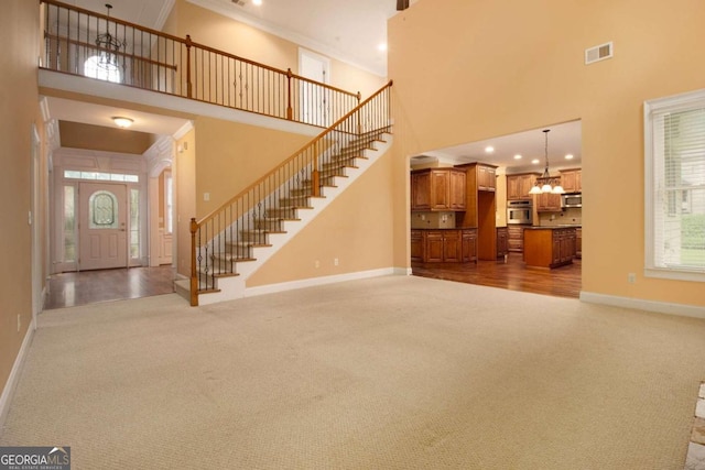 entrance foyer with a towering ceiling, ornamental molding, and dark hardwood / wood-style flooring