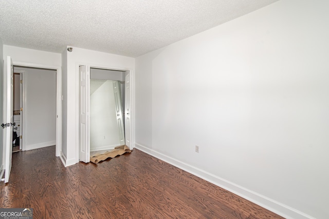 unfurnished bedroom with dark hardwood / wood-style flooring and a textured ceiling