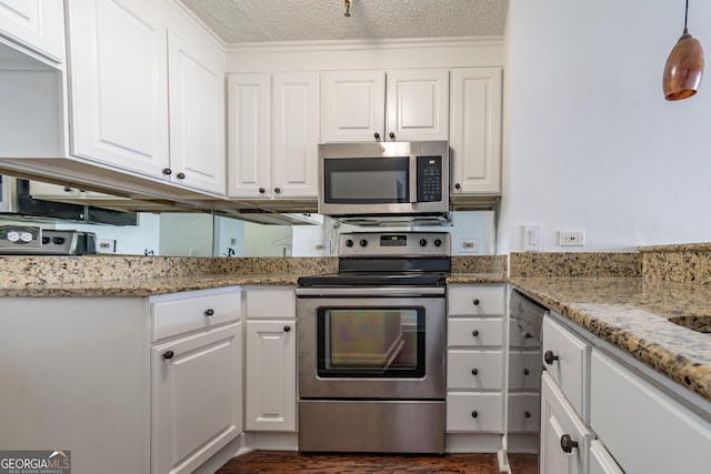 kitchen featuring stainless steel appliances, white cabinets, hanging light fixtures, and light stone countertops