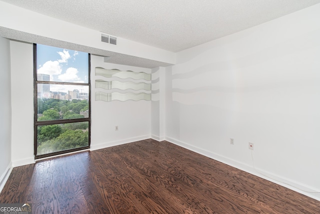 unfurnished room featuring hardwood / wood-style floors and a textured ceiling