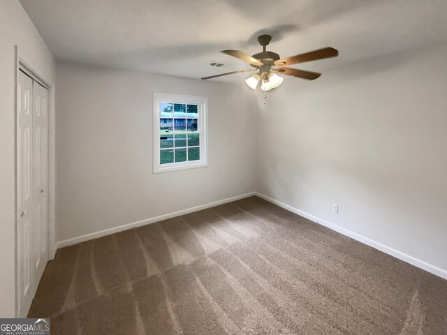 unfurnished bedroom featuring ceiling fan, a closet, and carpet floors