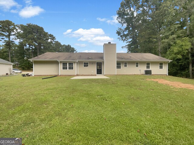 back of house with a lawn, a patio, and central AC