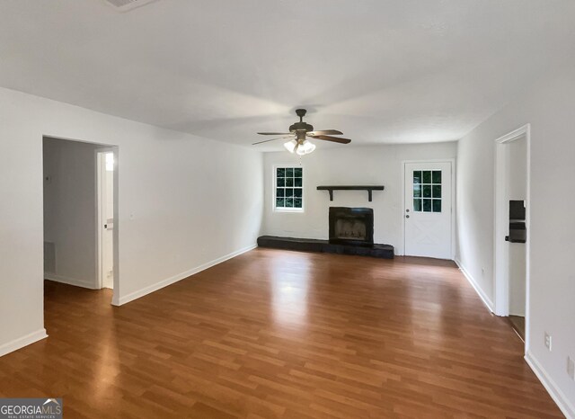 unfurnished living room featuring ceiling fan and hardwood / wood-style floors