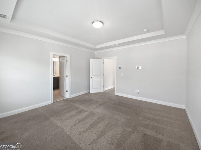 unfurnished bedroom with carpet flooring, connected bathroom, baseboards, and a tray ceiling