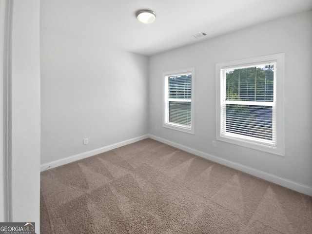 spare room with visible vents, carpet floors, and baseboards