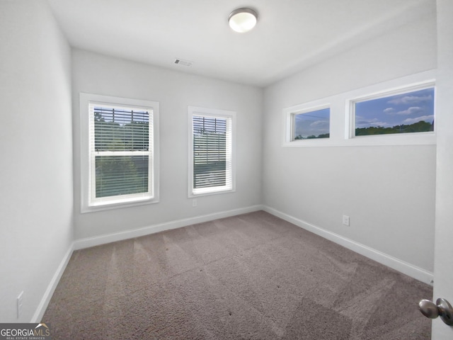 spare room with visible vents, baseboards, and carpet floors