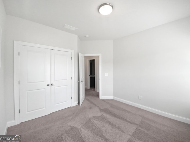 unfurnished bedroom featuring a closet, carpet flooring, and baseboards