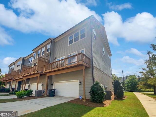 back of house featuring central AC, an attached garage, a yard, and driveway