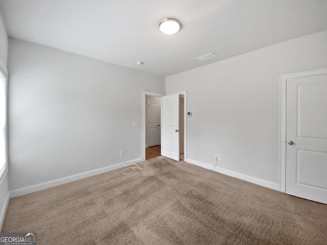 empty room with visible vents, baseboards, and carpet floors